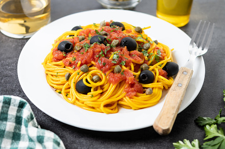 Italian Pasta puttanesca with tomato sauce, capers, and black olives on black s, a Food & Drink Photo by etorres69