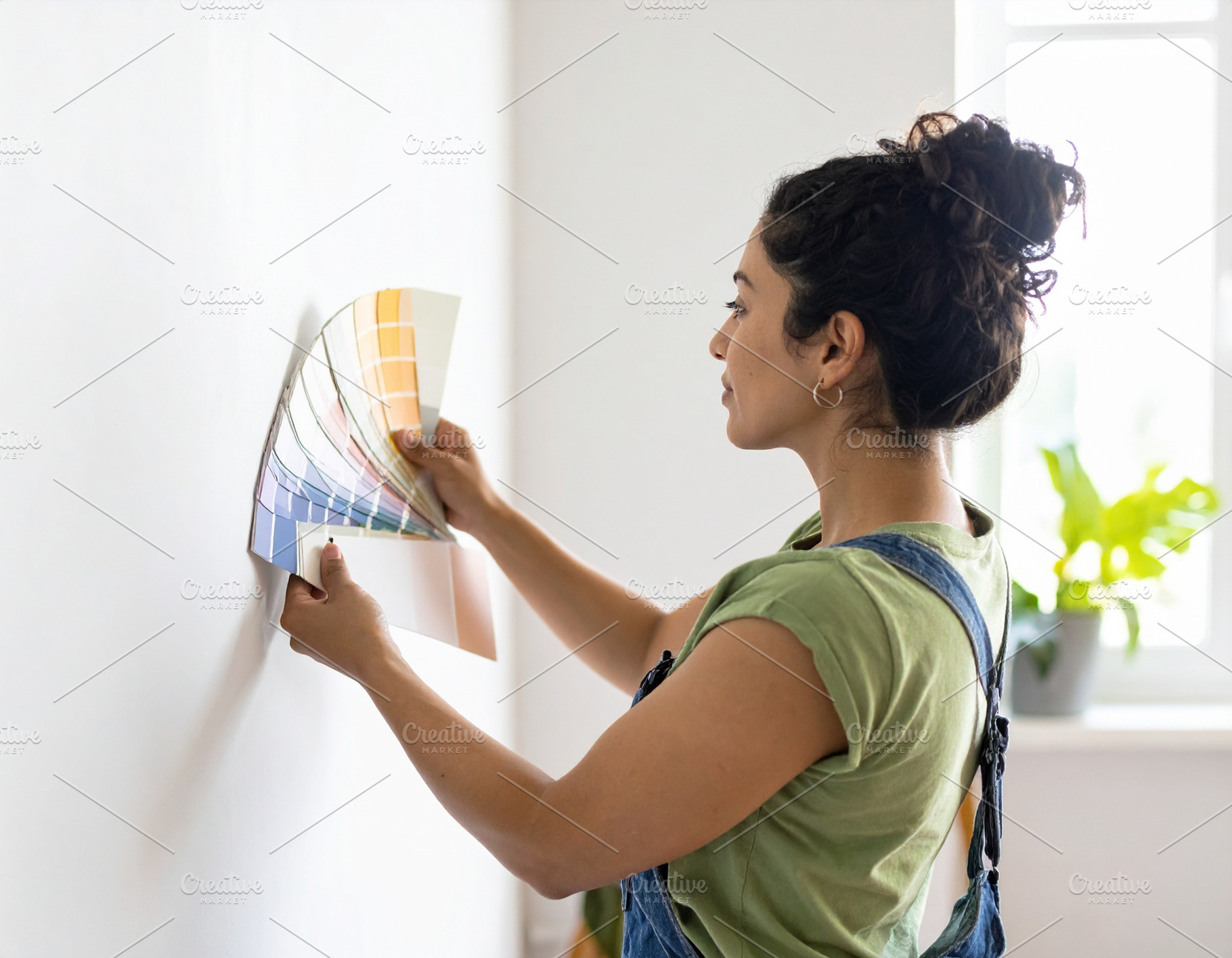 Home decorator showing wall paint samples to homeowners inside a, a Person Photo by DanFLCreativo