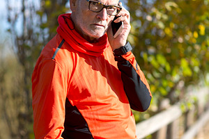 Senior man in sportswear talking on phone outdoors, a Sports & Recreation Photo by RF Images