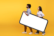 Young indian couple holding giant smartphone with mockup for design, yellow stu, a Photo by Prostock-Studio (Thumbnail 4 of 4)