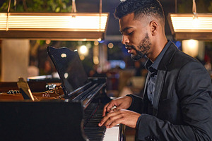 Adult pianist performing at the piano in a small bar, a Person Photo by DanFLCreativo