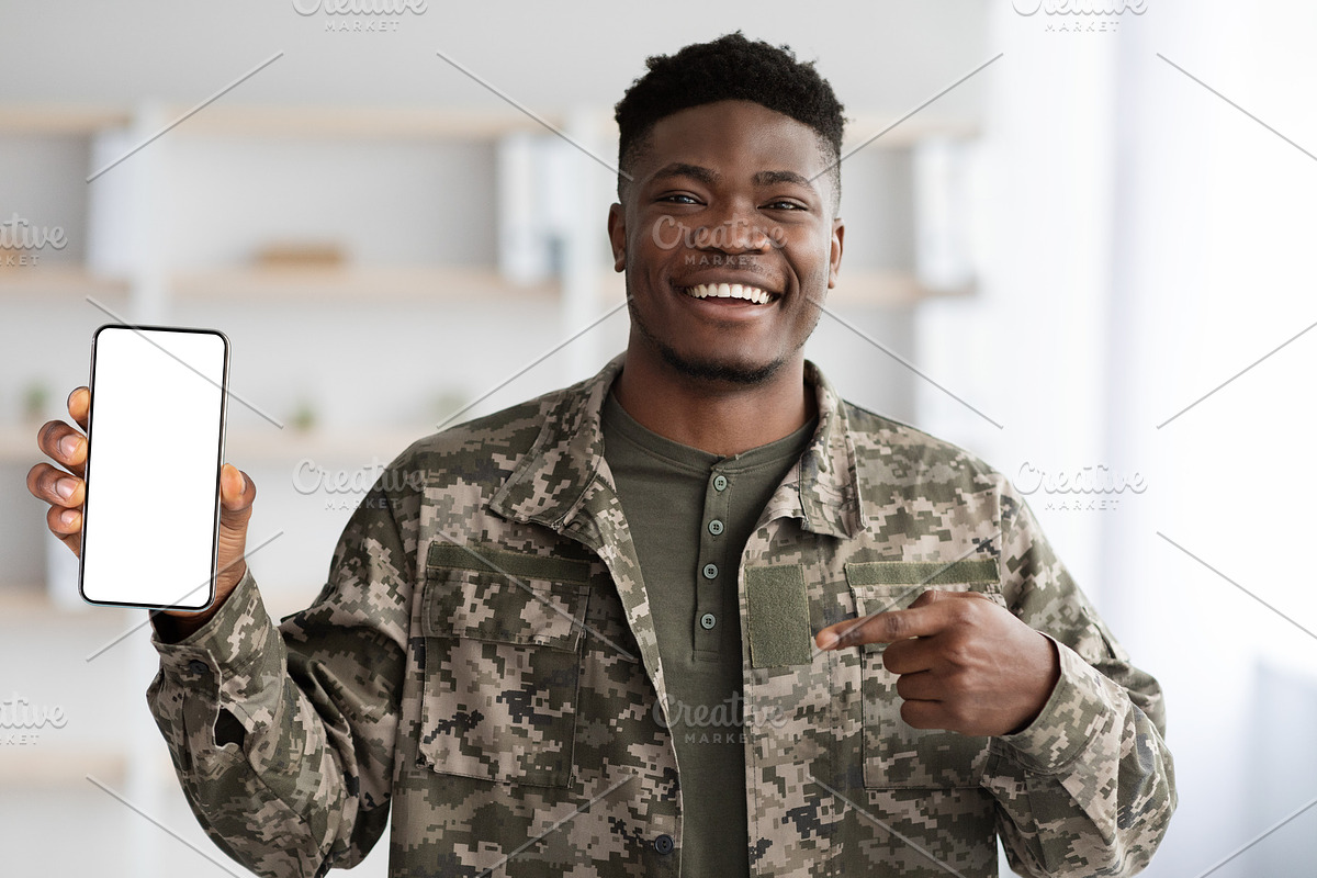 Happy black soldier in military uniform showing his smartphone, mockup, a Photo by Prostock-Studio (Photo 1 of 6)