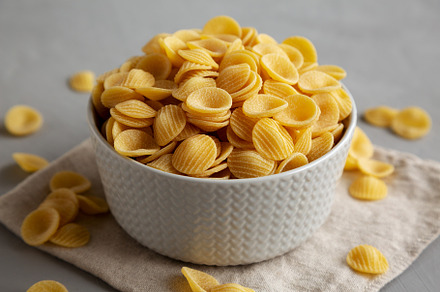 Dry, Uncooked Orecchiette Pasta in a Bowl, side view. Close-up., a Food & Drink Photo by LiudmylaChuhunova