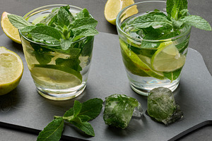Refreshing mojito cocktail with lime, mint, and ice on dark back, a Food & Drink Photo by ndanko