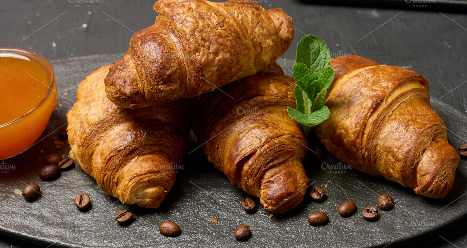 Freshly baked croissants on a black table, delicious breakfast, a Food & Drink Photo by ndanko