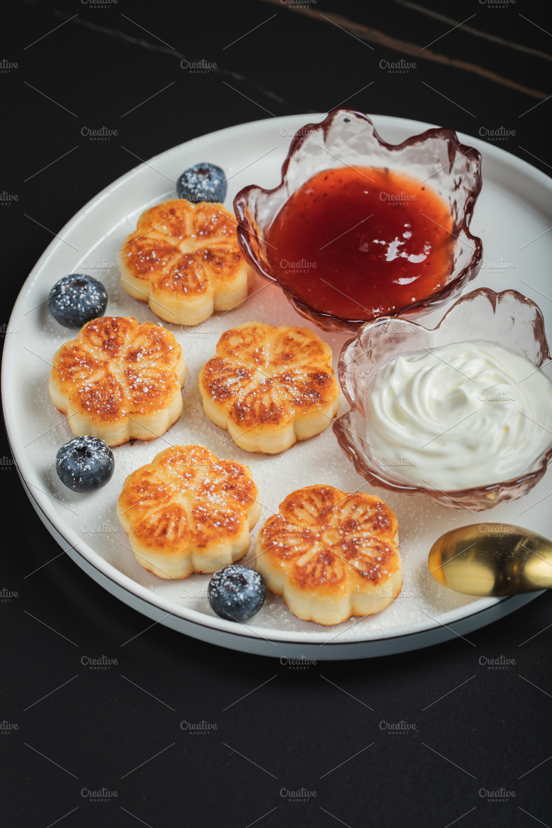 Cottage cheese pancakes, syrniki, curd fritters decorated with strawberry and r, a Food & Drink Photo by Budarinphoto