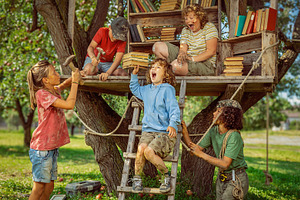 Children playing together around a treehouse in the woods, a Person Photo by DanFLCreativo