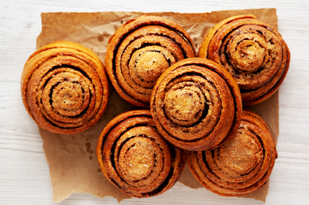 Homemade Cinnamon Roll Pastry on a white wooden background, top, a Food & Drink Photo by LiudmylaChuhunova