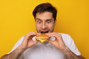 Funny Guy Holding Burger Biting Sandwich At Studio