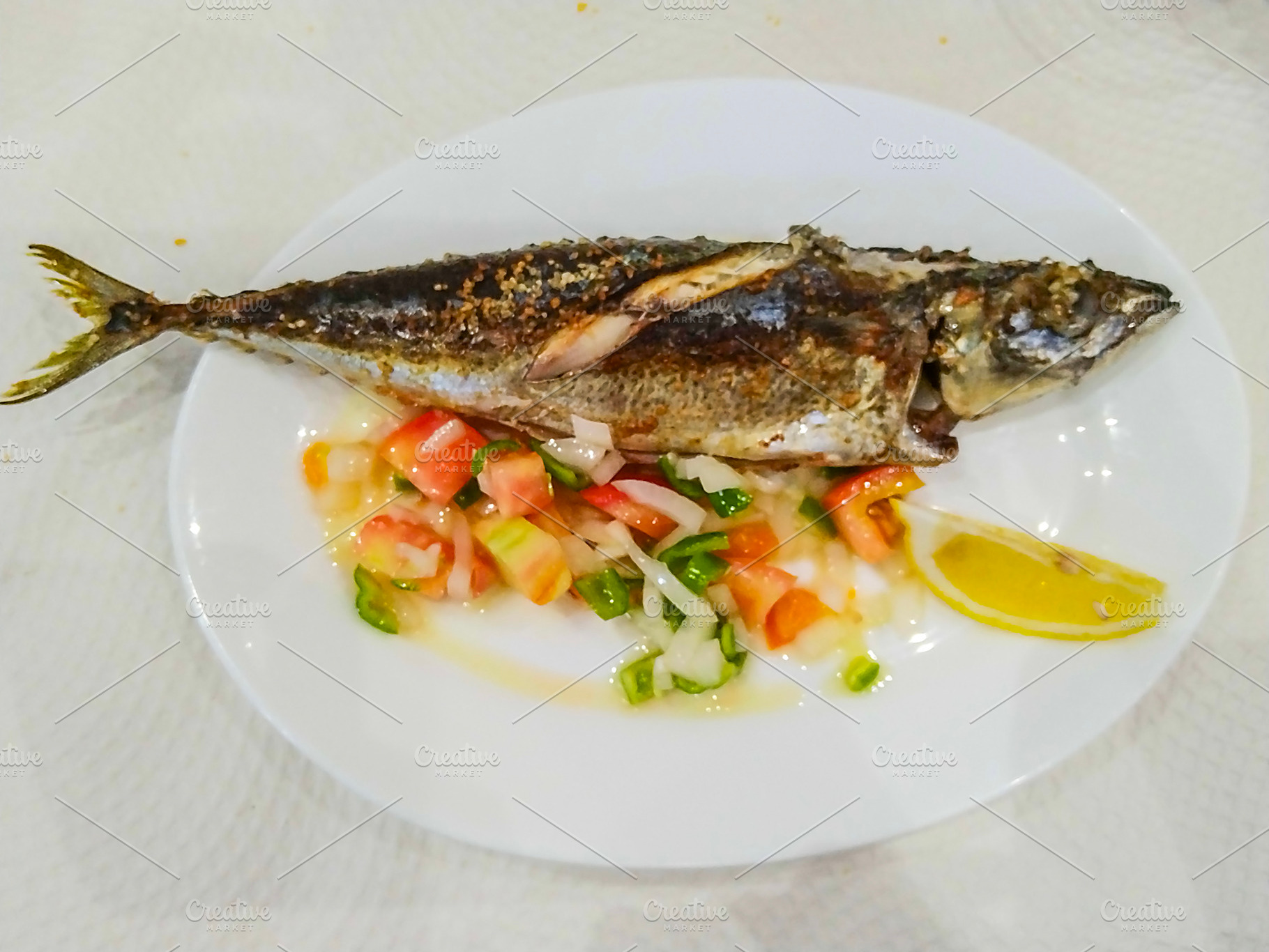 Grilled mackerel fish on white plate with salad, a Food & Drink Photo by DanFLCreativo