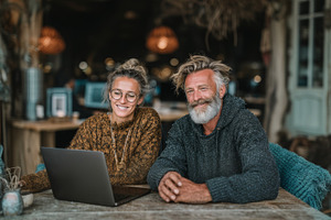 Two smiling professionals collaborating together on a laptop in a cozy workspac, a Business Photo by AS photostudio