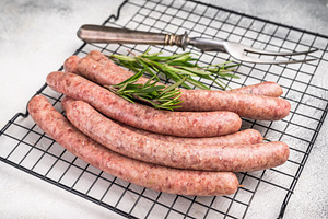 Fresh raw sausage links ready for grilling, perfect for barbecue, a Food & Drink Photo by composter-box@mail.ru