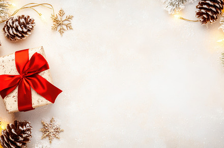 Top view of a neatly wrapped gift with red ribbon surrounded by pine cones and, a Holiday Photo by Mashimara