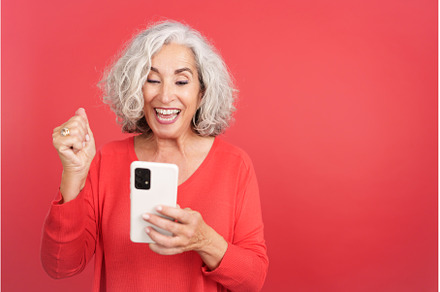 Mature woman celebrating while using, a Person Photo by Iván Moreno STOCK PHOTO