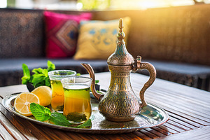 Moroccan tea on wooden table on terrace with sofas, a Food & Drink Photo by Davizro's Market