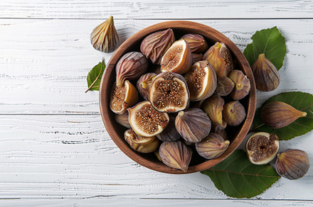 Dried figs fruit in bowl on wooden table, a Food & Drink Photo by AlyaAnd
