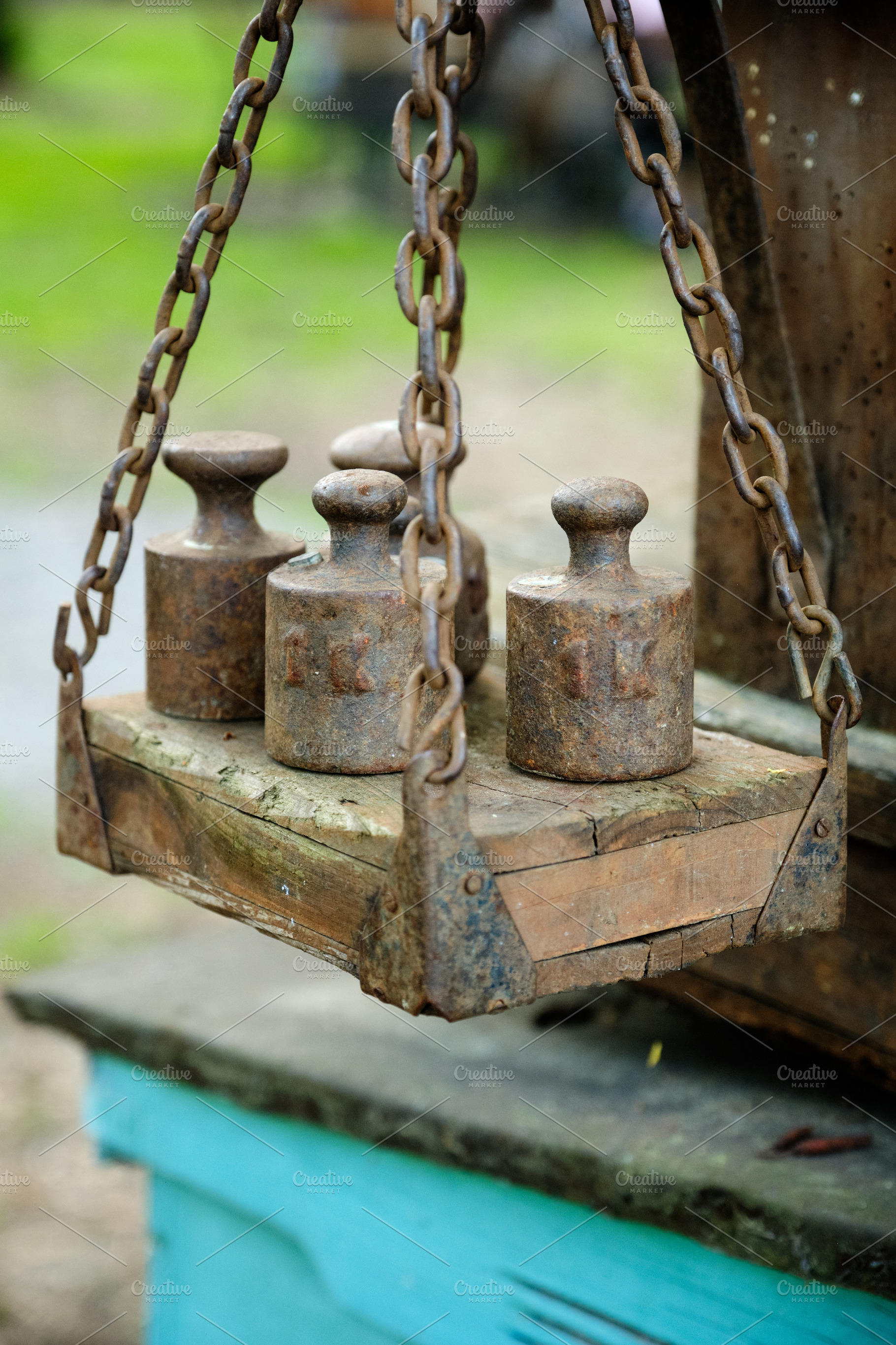 Close-up view highlights the textured wood and rusted chains of an antique bala, an Industrial Photo by Rohan Photography