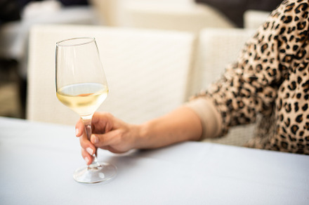 Glass of white wine in the hand of anonymous woman, a Person Photo by Iván Moreno STOCK PHOTO