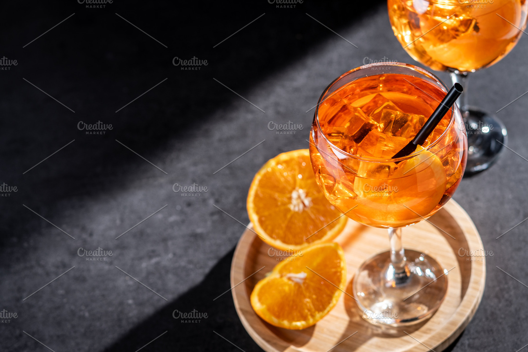 Refreshing Aperol Spritz cocktails with orange slices and ice in elegant glasse, a Food & Drink Photo by etorres69