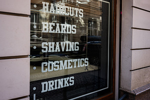Barber shop window display showcasing services like haircuts, cosmetics, and dr, a Photo by AS photostudio