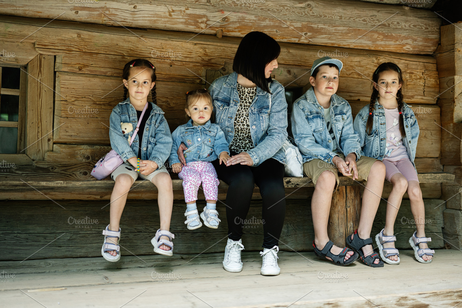 Family seated on a wooden bench outdoors in casual denim wear, a Person Photo by AS photostudio