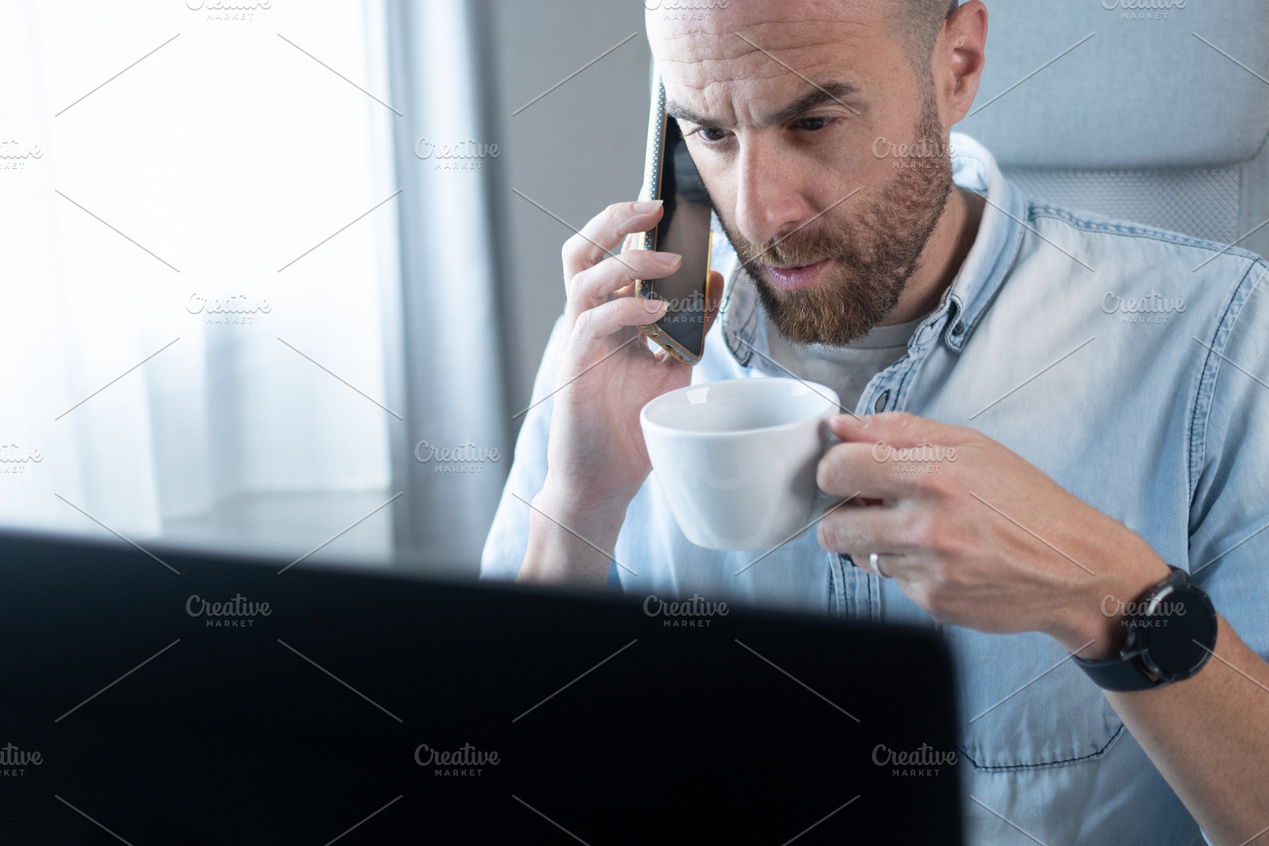 Businessman talking on smartphone while drinking coffee at home office, a Person Photo by etorres69