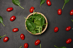 A wooden bowl filled with fresh spinach leaves surrounded by sca, a Food & Drink Photo by ndanko