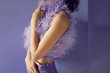portrait woman in an evening purple dress with feathers stands in the backgroun, a Person Photo by SaulichPhoto