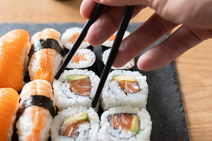 Woman eating sushi with chopsticks, a Food & Drink Photo by etorres69