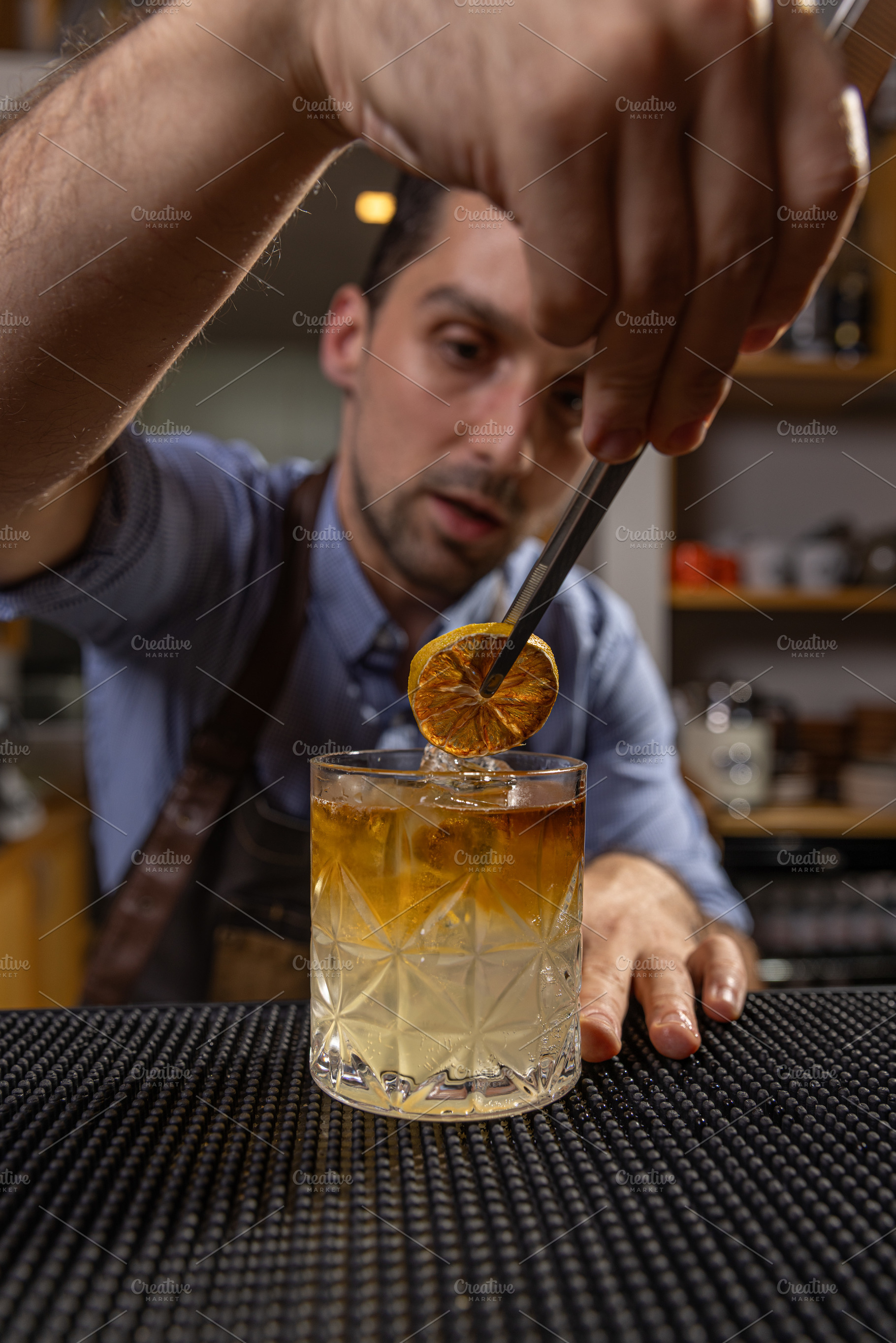 Bartender garnishing a cocktail, a Photo by Grafvision photography