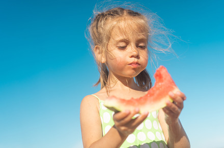 Funny little girl eat watermelon sunny summer day at ocean beach. Cute caucasia, a Person Photo by andreonegin market