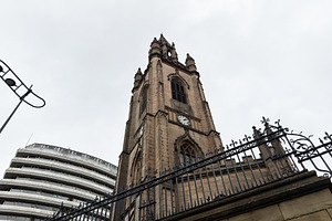 Historic Gothic church clock tower with ornate iron fence in Liv