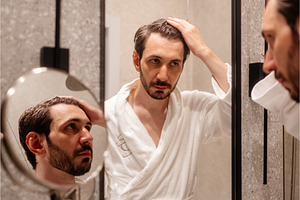 Man in a white robe examining his