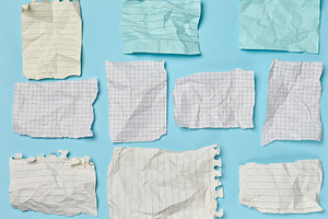 Crumpled and torn squared and lined paper sheets laid out on a b, a Business Photo by ndanko