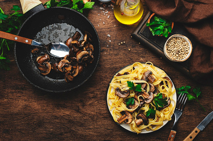 Tasty fettuccine pasta with mushrooms served on plate with green, a Food & Drink Photo by 5PH