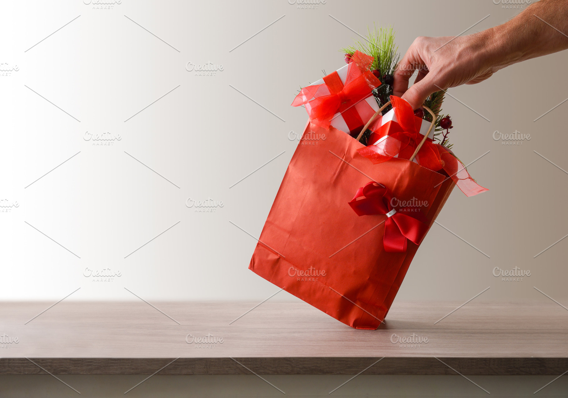 Conceptual detail of Christmas shopping with hand holding red ba, a Holiday Photo by Davizro's Market