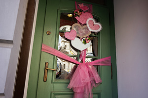 Decorated green door with pink ribbons and hearts celebrating a cheerful occasi, a Photo by AS photostudio