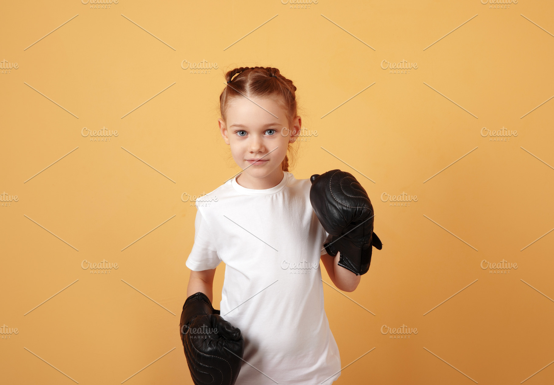 Young girl in white t-shirt with black boxing gloves stands read, a Person Photo by Ales Munt