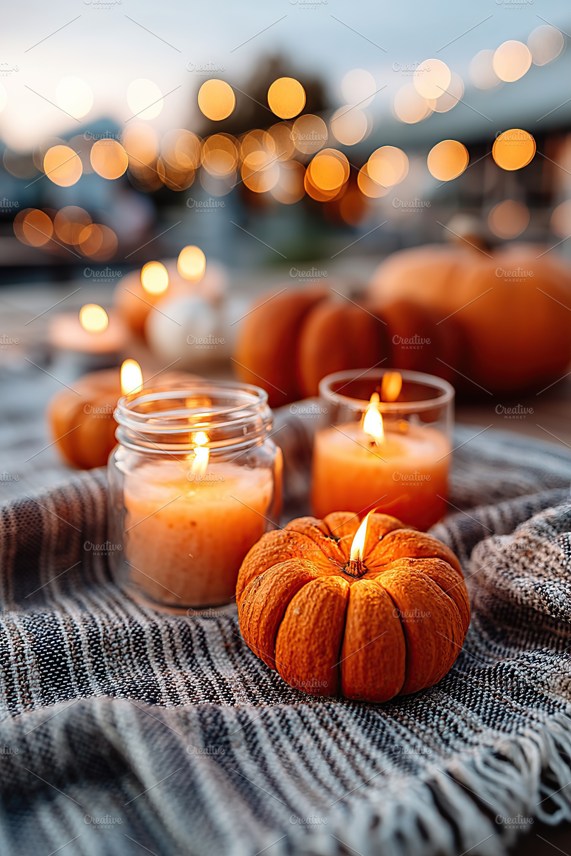 Cozy autumn evening with candles and pumpkins on a soft blanket outdoors, a Holiday Photo by AlyaAnd
