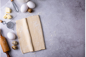 Raw puff pastry dough with baking, a Food & Drink Photo by Yulia Furman