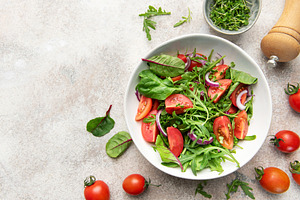 Fresh garden salad with tomatoes, greens, and onions, a Food & Drink Photo by Olena Rudo