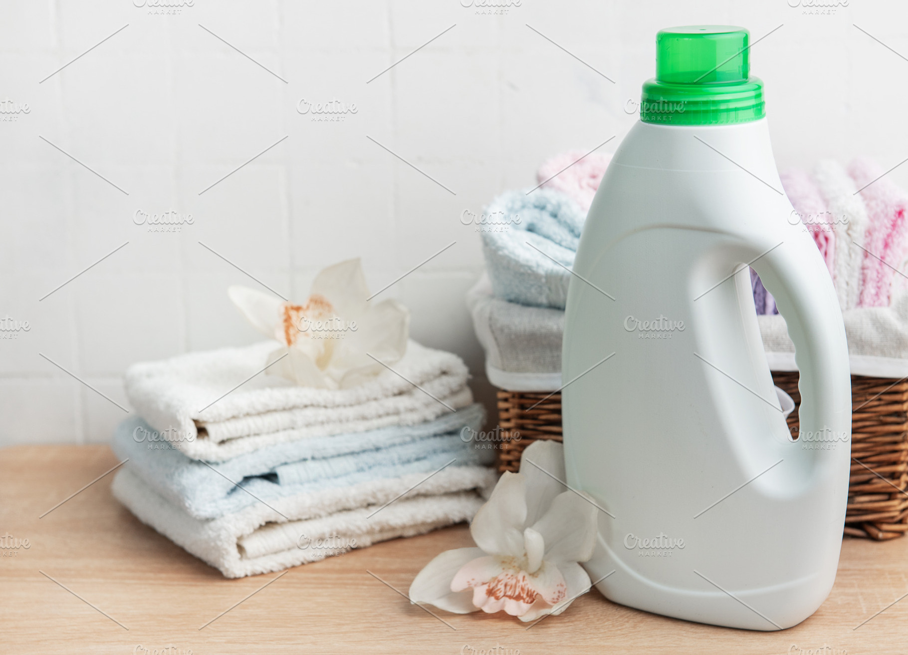 Laundry detergent bottle with fresh clean towels and orchids, an Industrial Photo by Olena Rudo