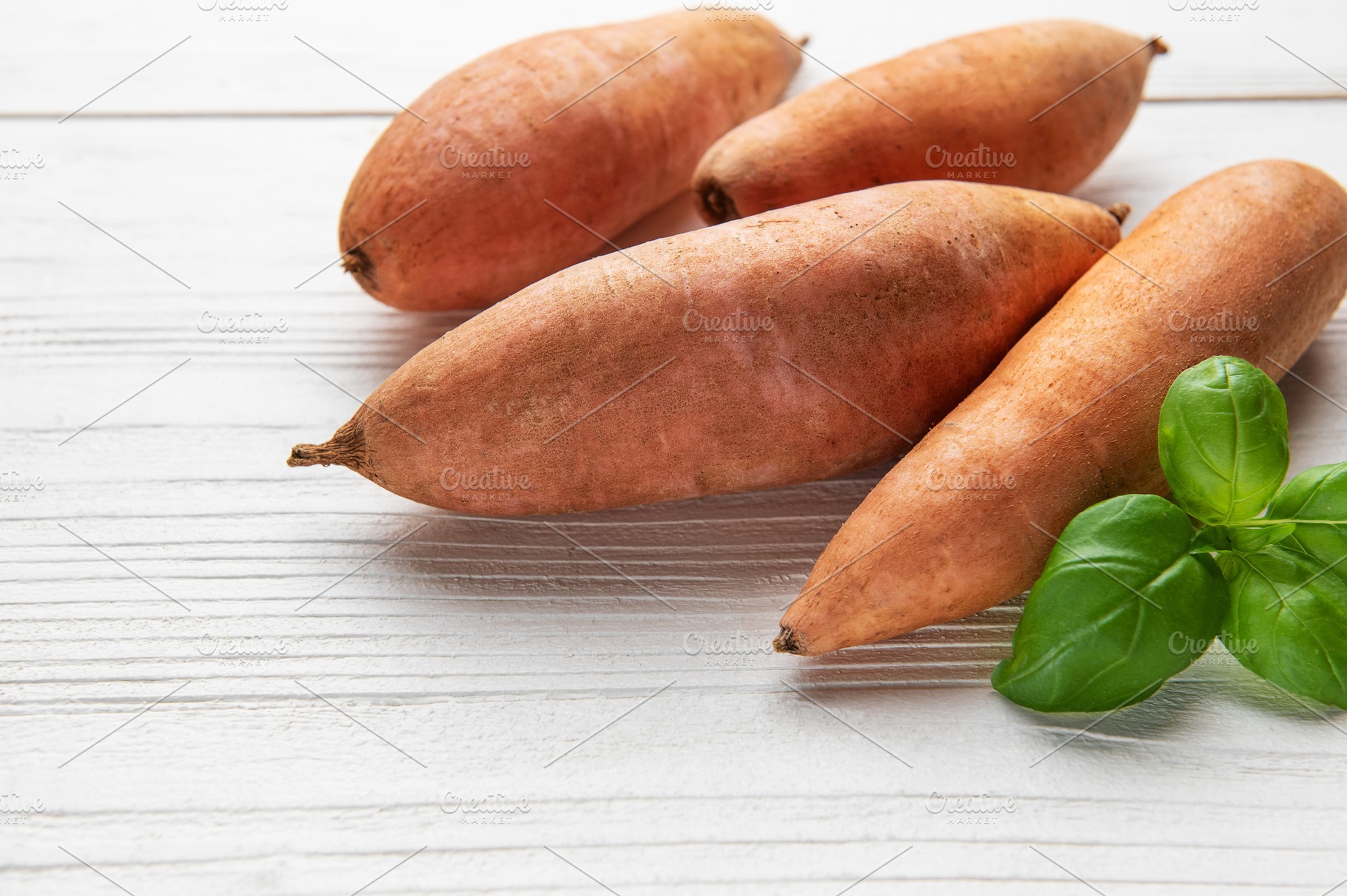 Sweet potatoes and fresh basil on white wooden table, a Food & Drink Photo by Olena Rudo