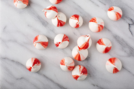 Peppermint meringues on a marble table, Christmas background