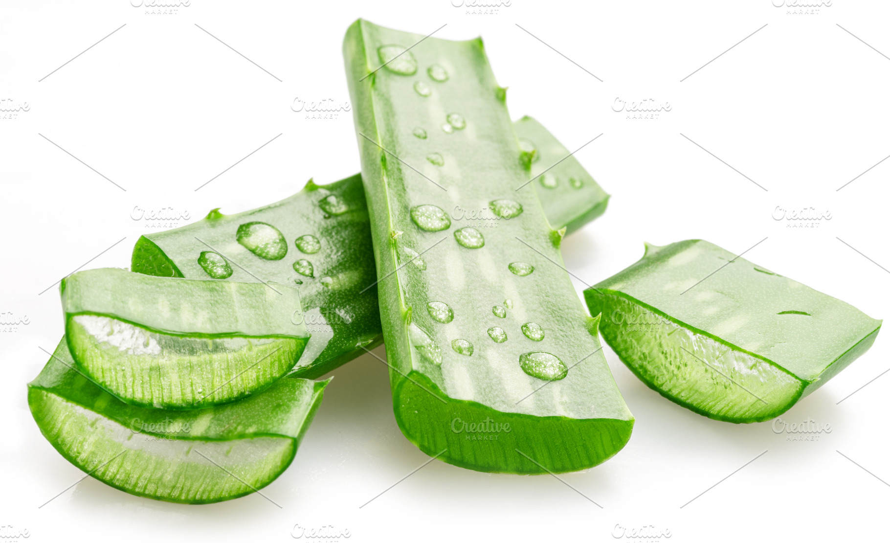Fresh cuts of aloe Vera leaf covered with water drops isolated o, a Health & Medical Photo by Volff