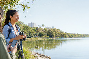 Young woman birdwatching by a serene, a Photo by Dvoevnore photos