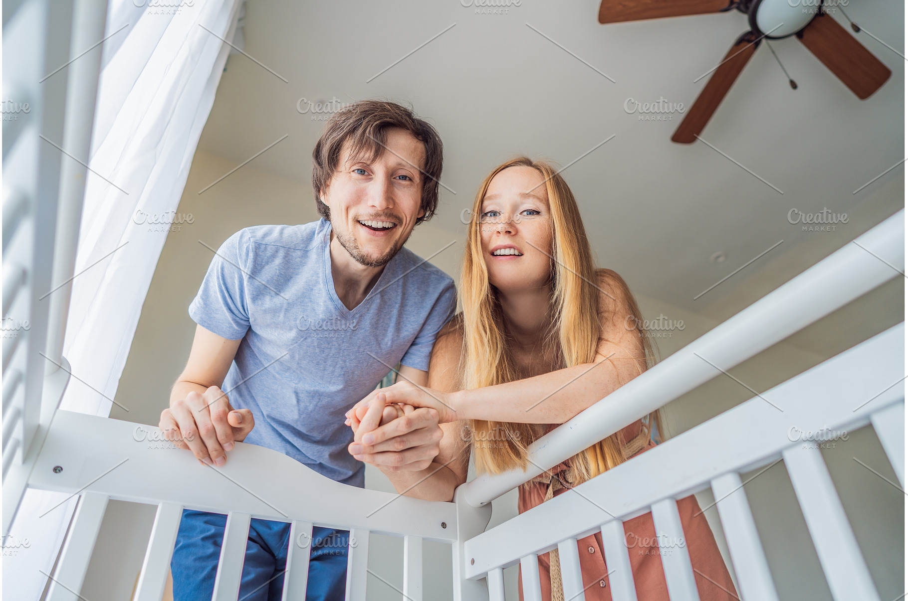 Parents looking into baby crib from, a Person Photo by Elizaveta Galitskaya