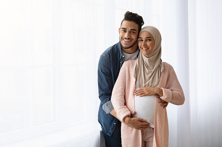 Pregnant Muslim Woman And Her Husband Embracing Near Window At Home, a Person Photo by Prostock-Studio