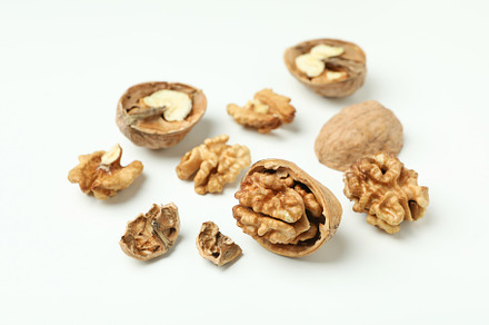 Walnuts with nutshell on white background, close up, a Food & Drink Photo by AtlasStudio PRO