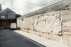Patched concrete wall and van, a Transportation Photo by SkyNext